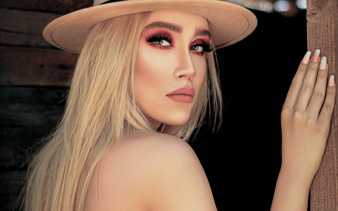 An AI generated blonde woman with a white top, a hat and eyeshadow that's a shade of red.